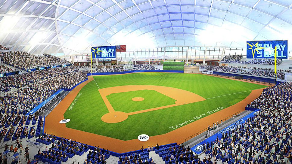 Interior rendering of a proposed Tampa Bay Rays stadium showing a covered ballpark design, seating bowl, baseball field, and Rays branding during a game-day setting.