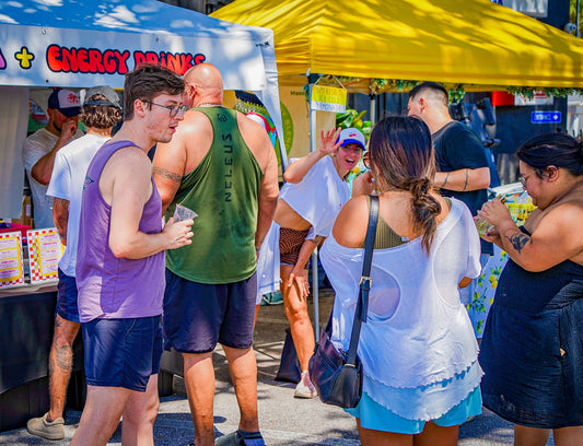 Shoppers browsing vendor booths at St. Pete Sunday Market in downtown St. Petersburg Florida with food tents, local makers, and outdoor community market atmosphere.