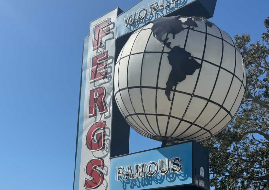 Close up of Ferg’s Sports Bar world globe sign and vertical lettering in downtown St Petersburg Florida near Tropicana Field on a sunny day
