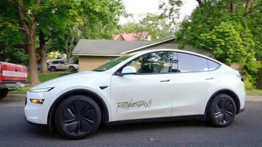 White Tesla Model Y Robotaxi driving through a residential neighborhood as Tesla launches its driverless ride service in Tampa, Florida.
