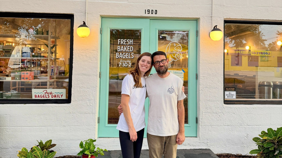 Two people outside the new Pete’s Bagels flagship at 1900 1st Avenue South in St. Pete’s Grand Central District, featuring the shop’s mint green entrance and fresh baked bagels signage.