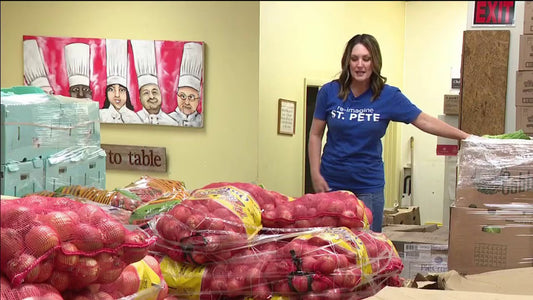 Volunteers at Positive Impact St. Pete organize fresh produce and recovered hospitality food from the Firestone Grand Prix of St. Petersburg, preparing meals for distribution to families across St. Pete.