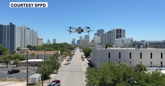 Police drone flying over downtown St Petersburg streets showing real time aerial surveillance and city skyline view in Florida